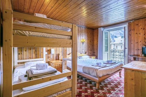 a bedroom with two bunk beds and a balcony at Hotel Le Chamonix in Chamonix-Mont-Blanc