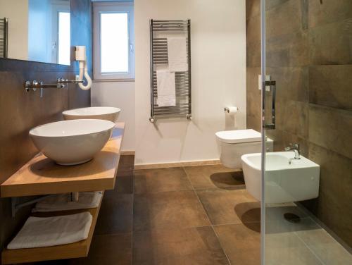 bagno con 2 servizi igienici e lavandino di Hotel Dimorae Rooms and Suites - Apartments a Civitanova Marche