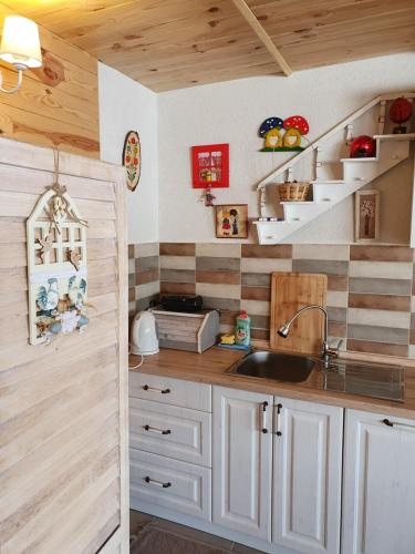 a kitchen with white cabinets and a sink and shelves at Holiday Home Vile Calimero in Žabljak