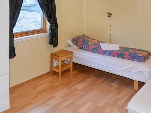 AukraにあるHoliday home Aukraのベッドとテーブル付きの小さな部屋