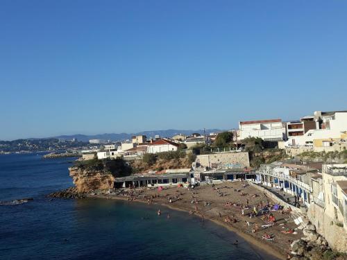 un groupe de personnes sur une plage près de l'eau dans l'établissement Chouette Cabanon sur la plage vue mer et terrasse privée, à Marseille