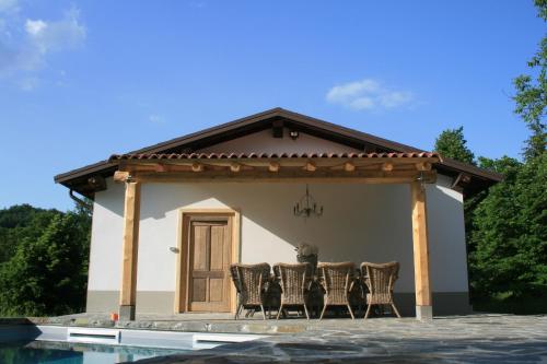 a group of chairs sitting under a pavilion next to a house at B&B Casale delle farfalle in Tornolo