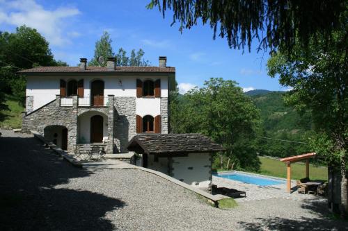a house with a swimming pool in front of it at B&B Casale delle farfalle in Tornolo