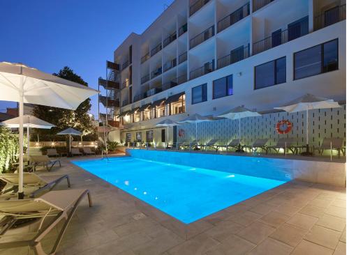 タラゴナにあるApartamento Nuriaの夜間のホテル正面のスイミングプール
