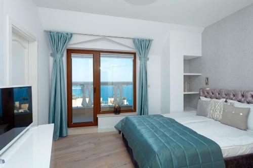 a bedroom with a bed and a large window at La Mer Penthouse in Varna City