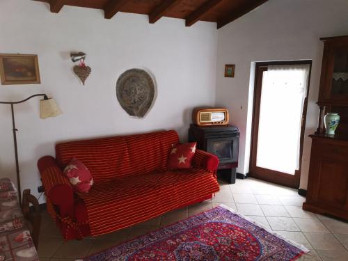 een woonkamer met een rode bank en een fornuis bij Casa Davide in Dolcedo