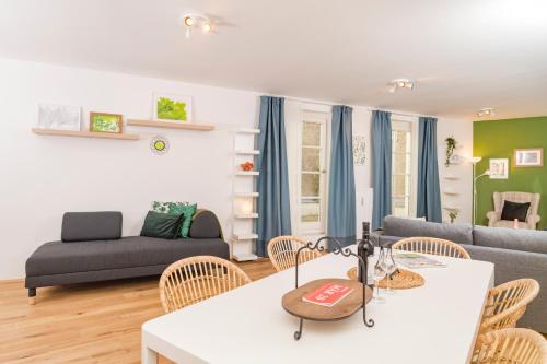 a living room with a couch and a table and chairs at Zum Grazer Uhrturm in Graz
