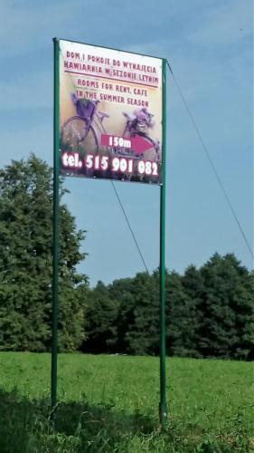 a sign in the middle of a field at Przy Trójstyku in Dubeninki