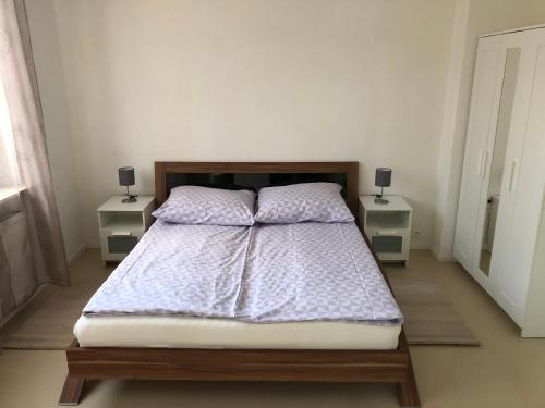 ein Schlafzimmer mit einem Bett mit zwei Nachttischen in der Unterkunft Apartment in OG Schaupenstiel in Northeim