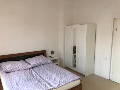 a white bedroom with a bed and a white cabinet at Apartment in OG Schaupenstiel in Northeim