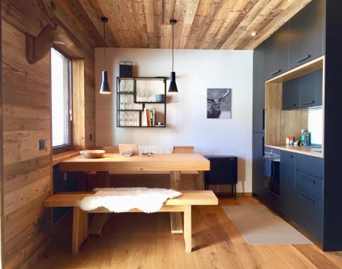 uma cozinha com uma mesa de madeira e um banco em Dolomiti Dreams em Selva di Val Gardena