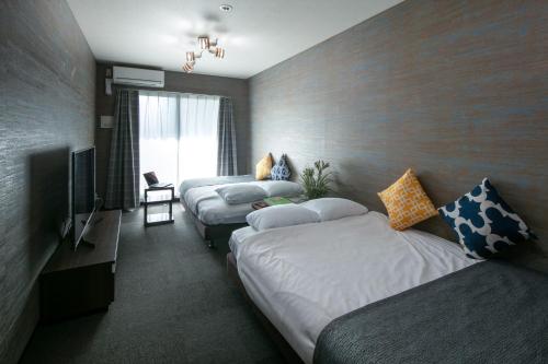 pokój hotelowy z 2 łóżkami i telewizorem w obiekcie Randor Residence Kyoto Classic w mieście Kioto