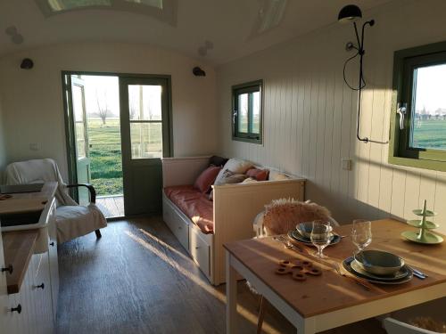 a living room with a couch and a table at Roulotte Hartemeers in Tielt