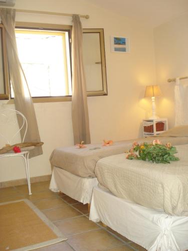 - une chambre avec 2 lits fleuris dans l'établissement Le Cabanon, à Farinole