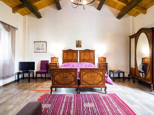 a bedroom with a wooden bed and a rug at Fontana del Cherubino in Santa Maria di Licodia