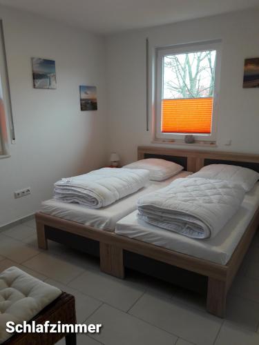 two beds in a room with a window at Haus Am Peenestrom in Peenemünde