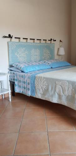 1 dormitorio con 1 cama con edredón azul en VelaLatina, en Stintino