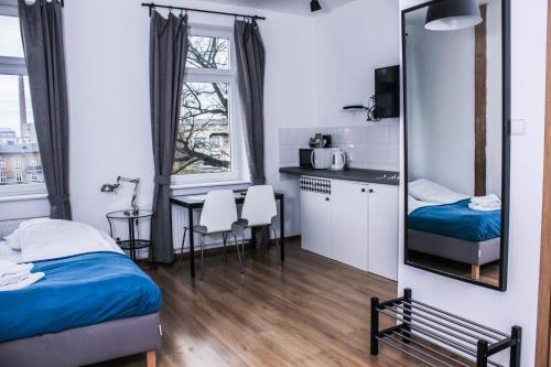 een slaapkamer met een bed, een spiegel en een tafel bij Apartamenty Babina in Kalisz