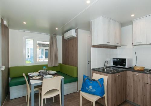 a kitchen with a table and chairs in a room at Club del Sole Vigna sul Mar Family Collection in Lido di Pomposa