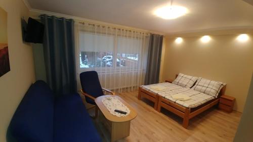 Pokoje Beskidy في فيسلا: غرفة معيشة مع أريكة وطاولة