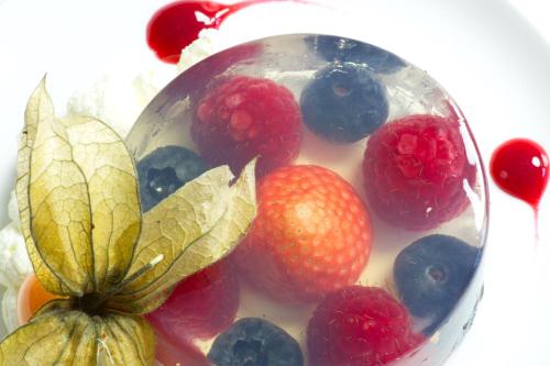 a bowl of fruit with raspberries and blueberries at Tyn Rhos Country House in Caernarfon