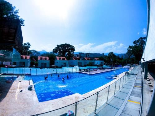 a large swimming pool with people in the water at Apartasol de Lujo Santa Fe de Antioquia" in Santa Fe de Antioquia