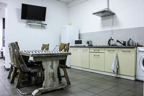 a kitchen with a table with chairs and a sink at Pokoje Babina in Kalisz