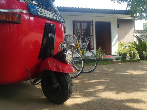 a red van with two bikes parked in front of a house at ARANI HOMESTAY in Polonnaruwa