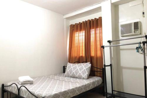 een kleine slaapkamer met een bed en een magnetron bij 500Mbps Wi-Fi 2-Story Apartments in Cebu City