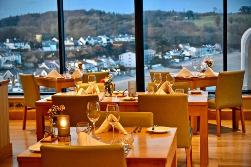a restaurant with tables and chairs and a view of a harbor at St Brides Spa Hotel & Village Apartments in Saundersfoot
