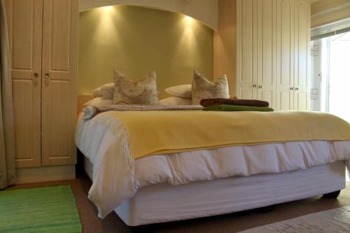 Un dormitorio con una cama con sábanas y almohadas blancas. en Somerset West Vacation Rental - Experience the Best of Cape Town - Wine, Golf, Sea, en Somerset West