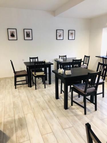 a dining room with black tables and chairs at Villa Kmeller in Lviv