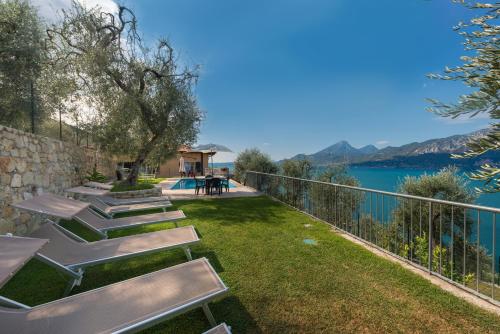 a garden with benches and a view of the water at Agricampeggio Relax (Campsite) in Brenzone sul Garda