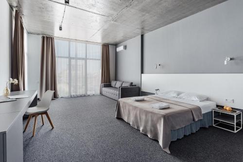 a bedroom with a bed and a desk and a couch at WELCOME summer in Zatoka