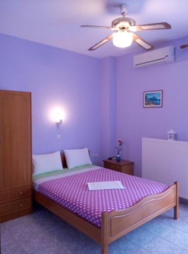1 dormitorio con 1 cama y ventilador de techo en StamFlor Studios, en Porto Koufo