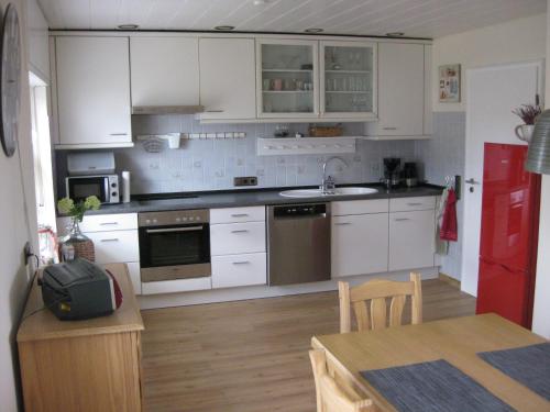 a kitchen with white cabinets and a kitchen table with a tableablish at Bella Colonia Vieren in Hürth