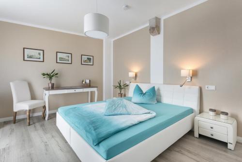 1 dormitorio con cama con sábanas azules y escritorio en Kleines feines Ferienhaus im Herzen von Dresden en Dresden