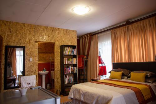 Un dormitorio con una cama y una estantería. en Blyde Guesthouse, en Benoni