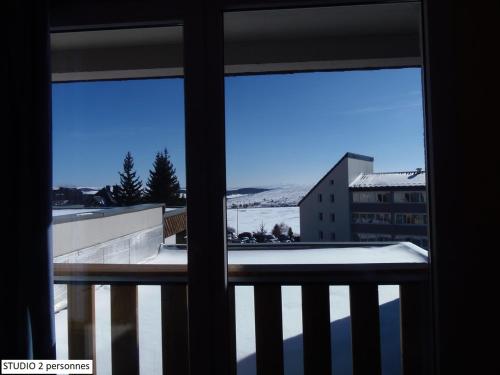 a view from a window of a balcony with snow at Les Aliziers in Super Besse