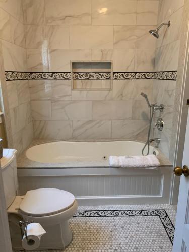 a bathroom with a toilet and a bath tub at Almondy Inn Bed & Breakfast in Newport