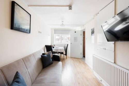 ein Wohnzimmer mit einem Sofa und einem Tisch in der Unterkunft 145 Burnley Road in London