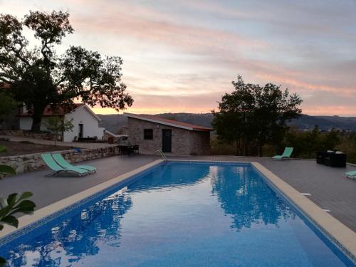a swimming pool in front of a house at Quinta dos Carvalhais - Serra da Estrela in Fornos de Algodres