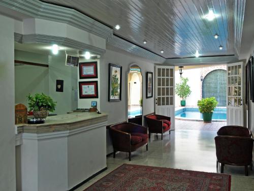 a lobby with a bar and chairs and a pool at Hotel Splendid in Fez