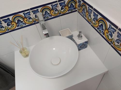 W łazience znajduje się biała umywalka oraz niebiesko-białe kafelki. w obiekcie Benamara Gardens, Apartment with Pool, 100m from Beach near Marbella & Estepona w mieście Estepona