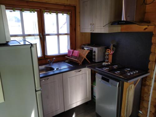 a kitchen with a sink and a stove top oven at chalets les 5 loups in Gerbépal