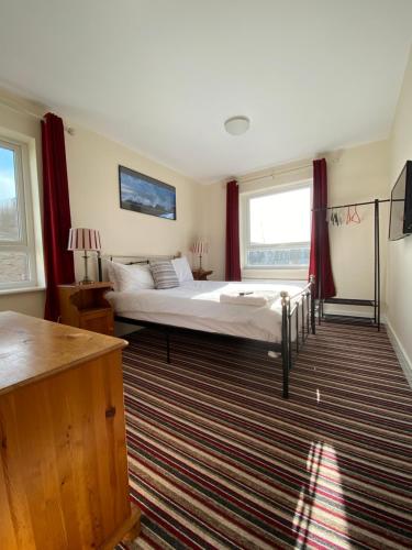 1 dormitorio con 1 cama grande y cortinas rojas en Mary Green Walk, en Canterbury
