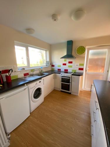a kitchen with a washer and dryer at Mary Green Walk in Canterbury
