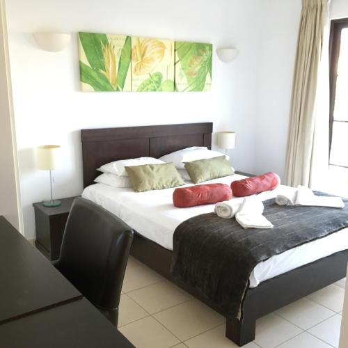 a bedroom with a bed with red pillows on it at Tortuga Beach Villa in Santa Maria