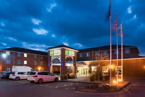 un bâtiment avec des voitures garées dans un parking dans l'établissement Holiday Inn Express Southampton West by IHG, à Southampton