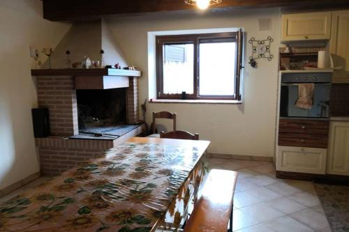 kuchnia ze stołem i kominkiem w obiekcie Residenza Il cortile w mieście Monte San Martino